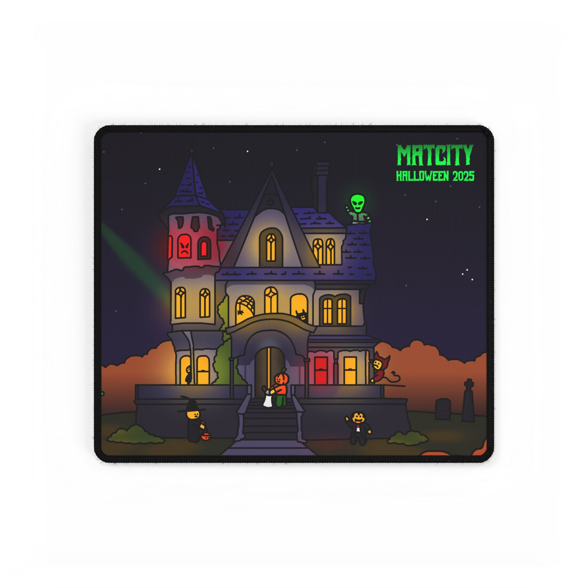 Compact Matcity Halloween 2025 Mouse Pad showing a haunted house scene with glowing windows and small costumed characters.