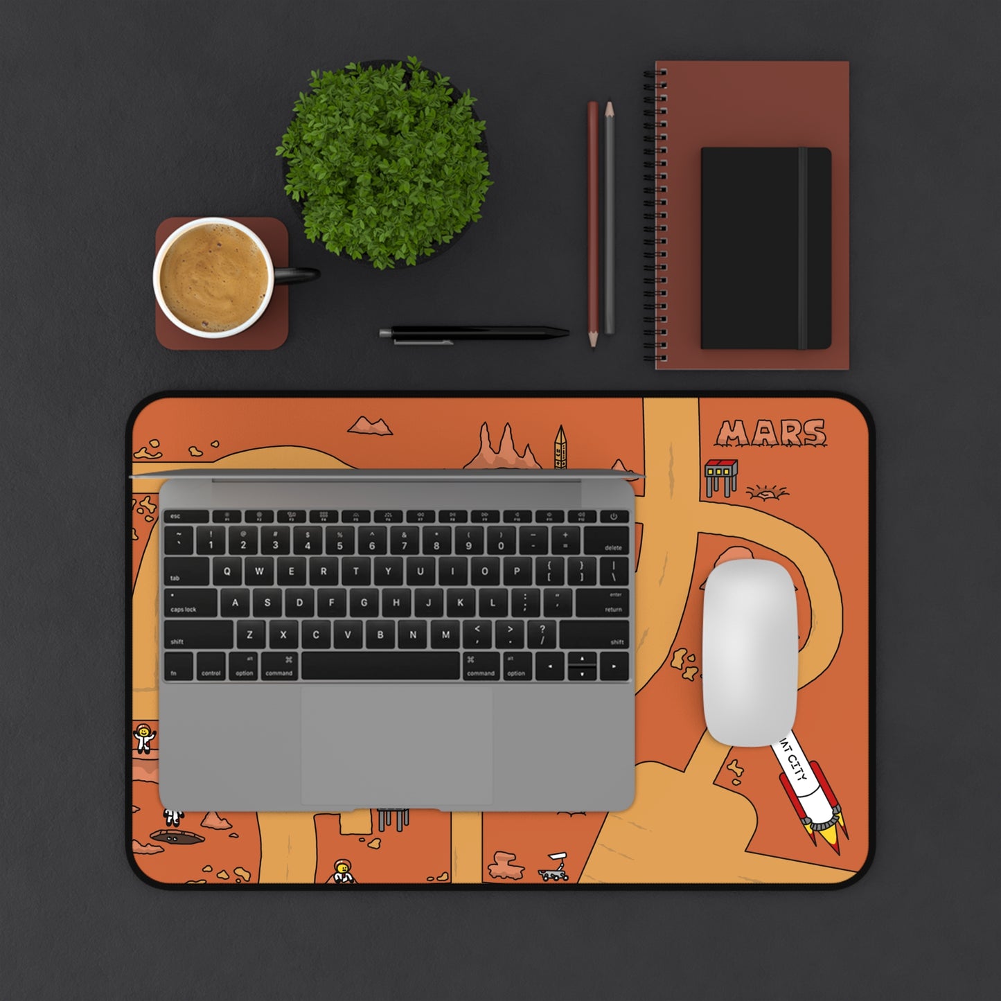 A top-down view of the Matcity Mars Mouse Mat Medium under a laptop and mouse, emphasizing how it fits perfectly into a desk setup while displaying the fun Mars-themed design.