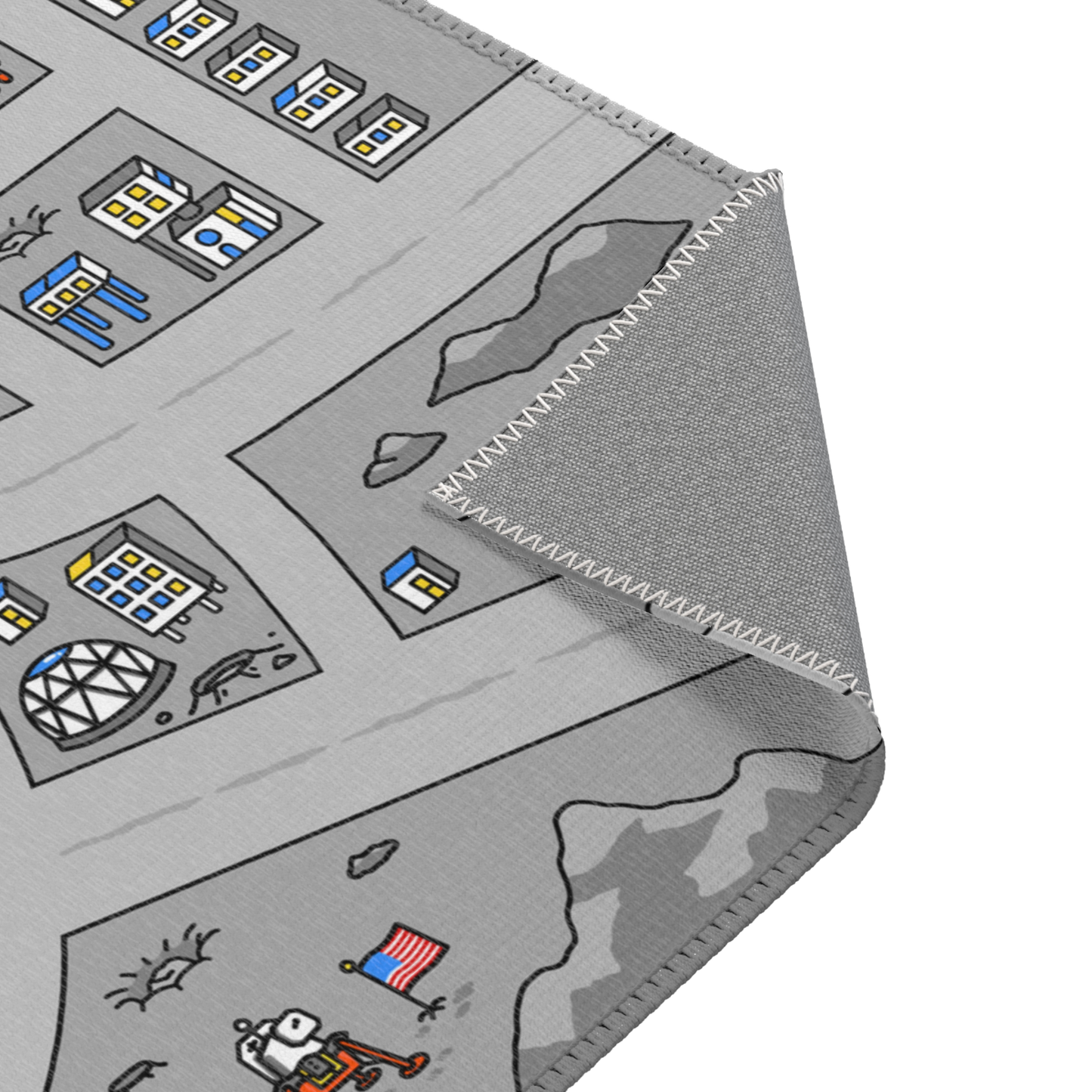 A close-up of the Matcity Moon Mat, partially folded. The image highlights detailed stitching around the edges and the lunar base design with roads, buildings, and astronauts.