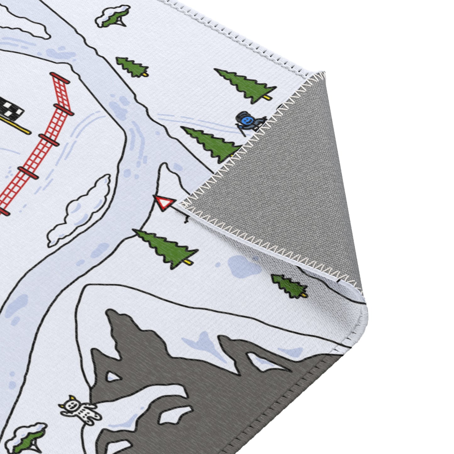 Close-up of the Snow Rally Mat’s corner, highlighting detailed stitching along the edge with trees and snowy paths in the design.