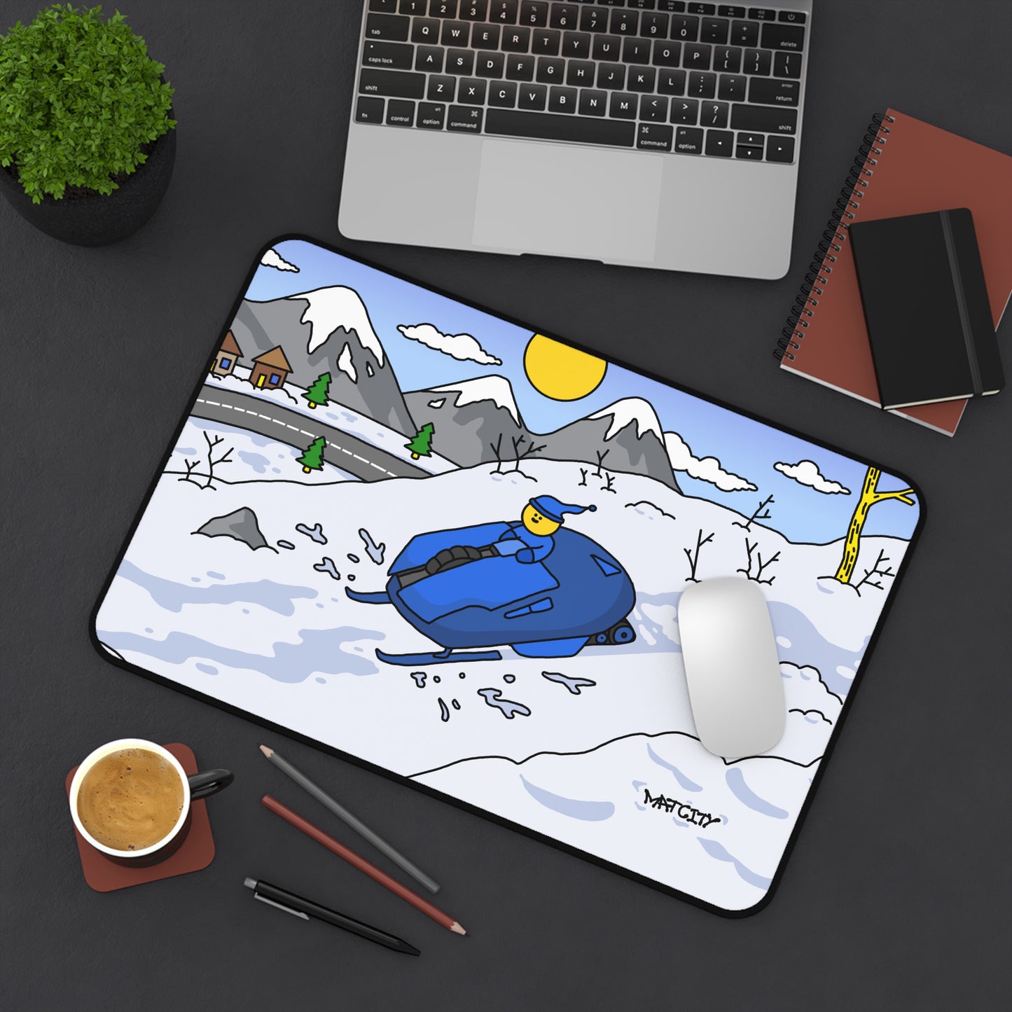 The Matcity Snow Rally Mousepad placed on a desk setup with a laptop, adding a winter-themed style to the workspace.