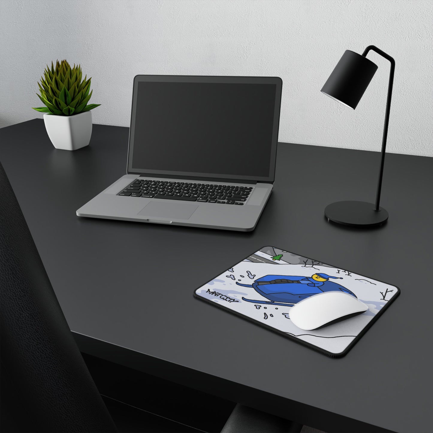 Matcity Snow Rally Mousepad Small on a black desk next to a laptop, with a white mouse on top.