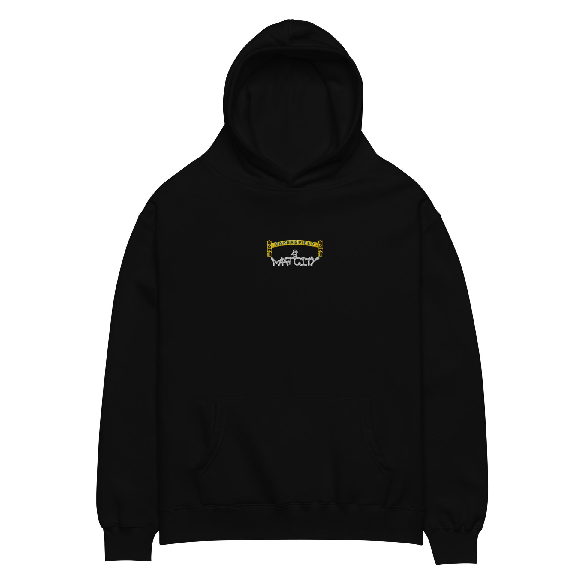 Black pullover hoodie laid flat. Small chest embroidery depicts a yellow Bakersfield arch with a tiny worker above white “Matcity” graffiti text. Kangaroo pocket and ribbed cuffs visible.