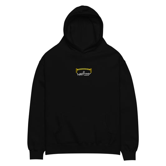 Black pullover hoodie laid flat. Small chest embroidery depicts a yellow Bakersfield arch with a tiny worker above white “Matcity” graffiti text. Kangaroo pocket and ribbed cuffs visible.