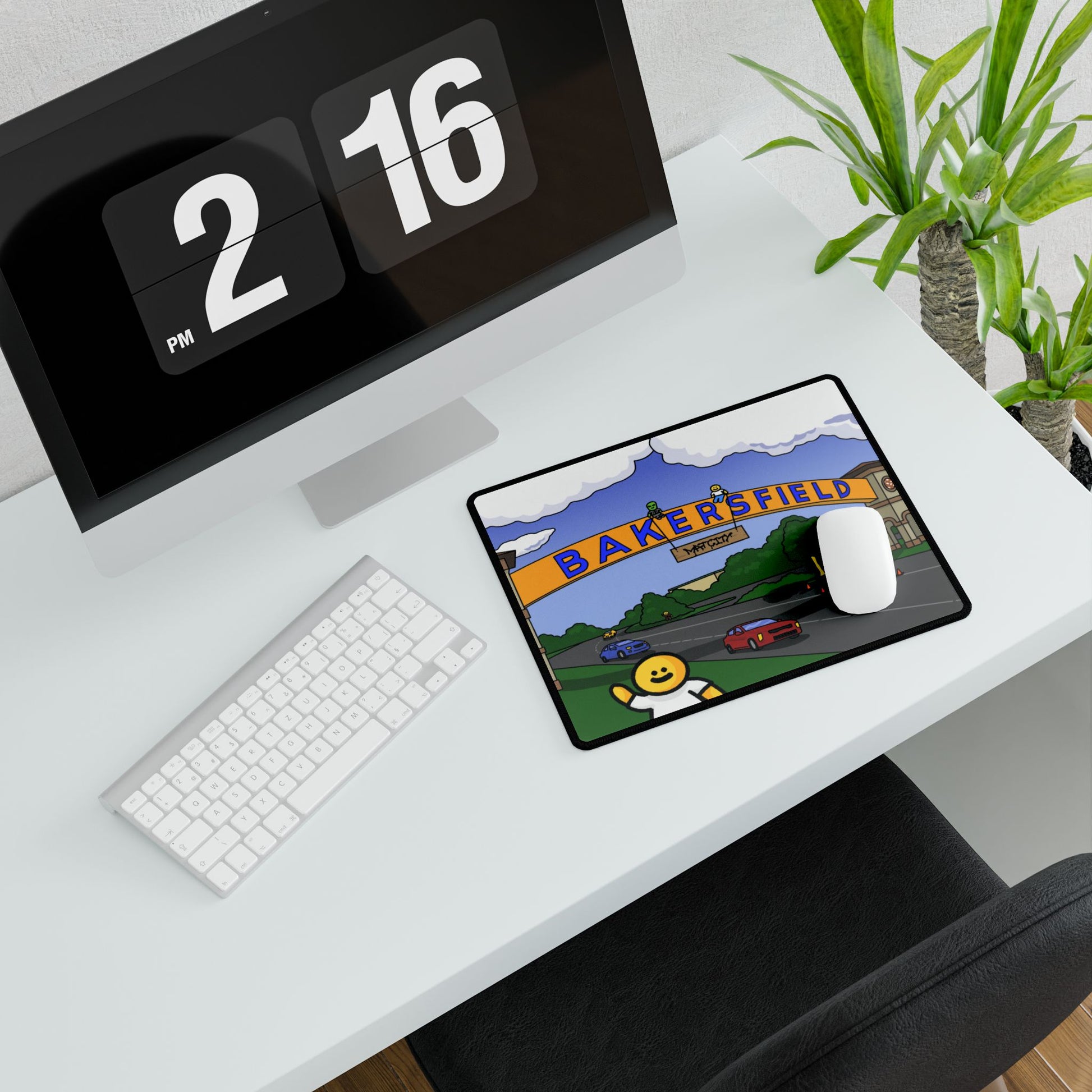 Small Bakersfield mouse pad beside keyboard; arch graphic and waving figure pop against the minimalist white desk.