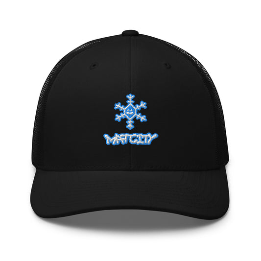 Black trucker cap with mesh back, front panel shows bold blue embroidered snowflake above Matcity graffiti logo.