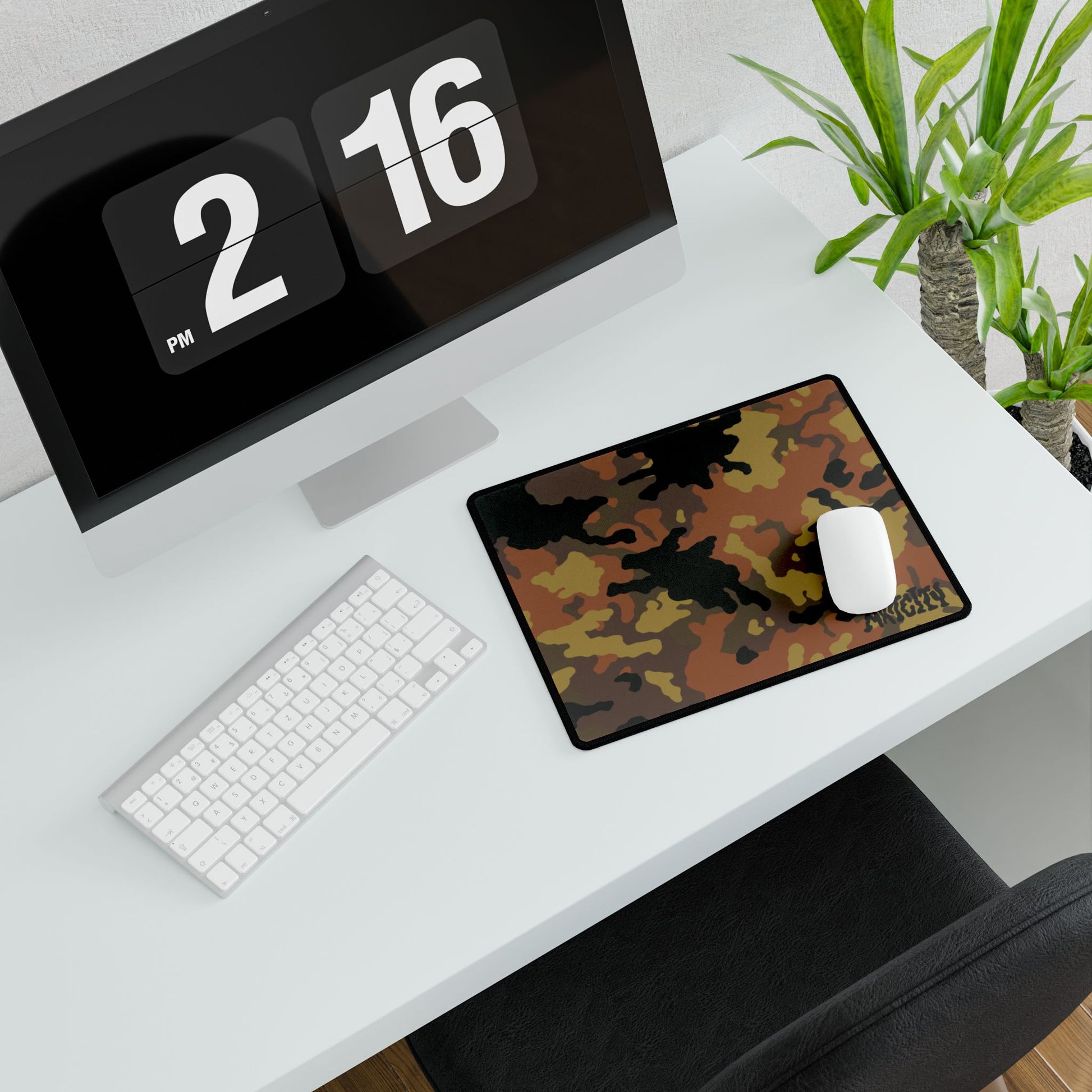 Desk setup with a computer, keyboard, mouse, and fall camouflage mouse pad.