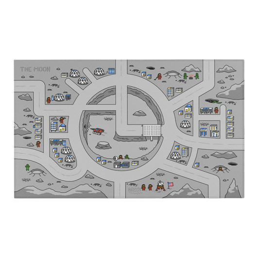 A top-down view of the Matcity Moon Mat. The design features roads, domes, and astronauts on a lunar base with a grayscale color scheme, accented by blue and white buildings.