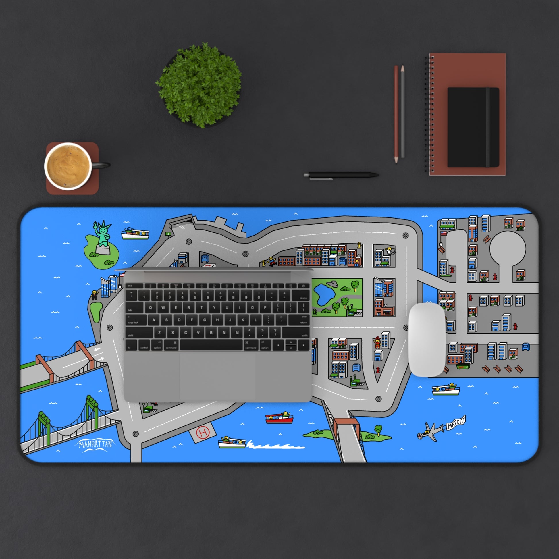 Overhead view of a desk setup with the Matcity New York Mouse Mat Large, a laptop, mouse, and plant. The colorful urban layout stands out on the dark desktop.