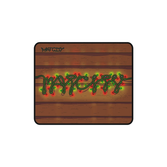 A small-sized mouse pad with a wood plank background featuring "Matcity" spelled out in green and red fairy lights.