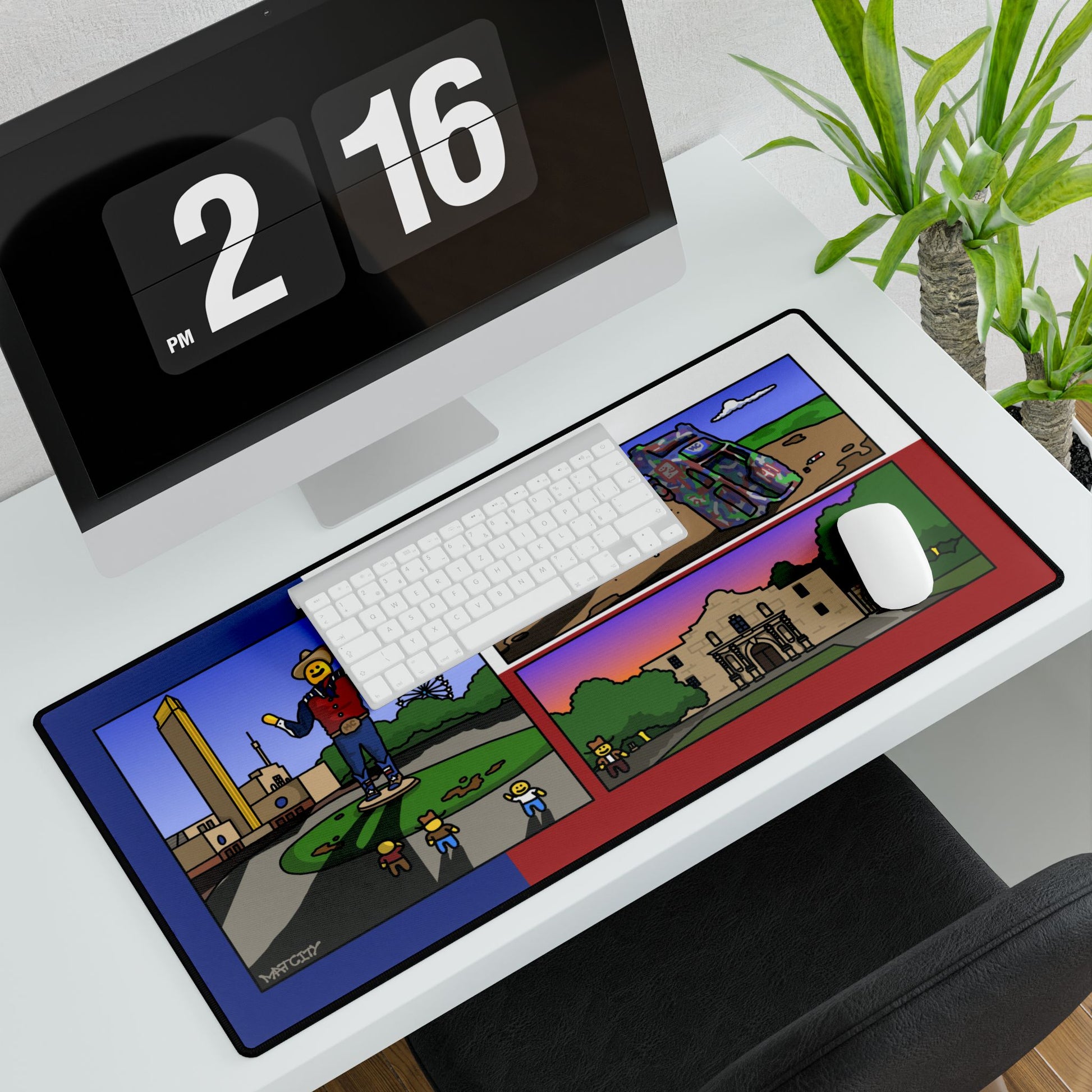 Overhead office view; keyboard and mouse sit on the large landmark desk pad beside a monitor and plant.