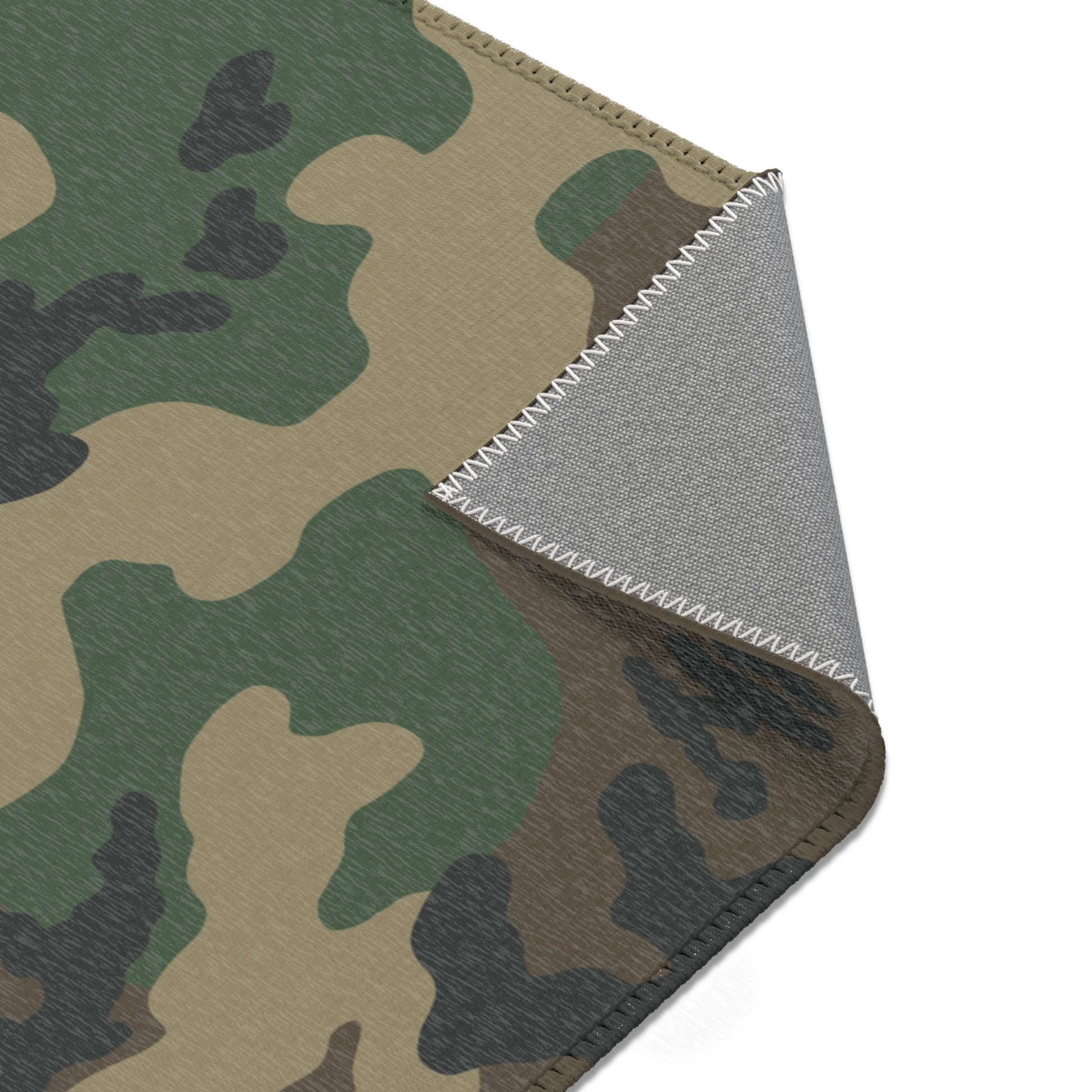 Woodland camouflage patterned rug with a textured gray underside shown on a white background