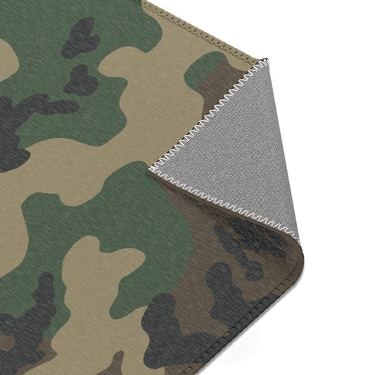 Woodland camouflage patterned rug with a textured gray underside shown on a white background