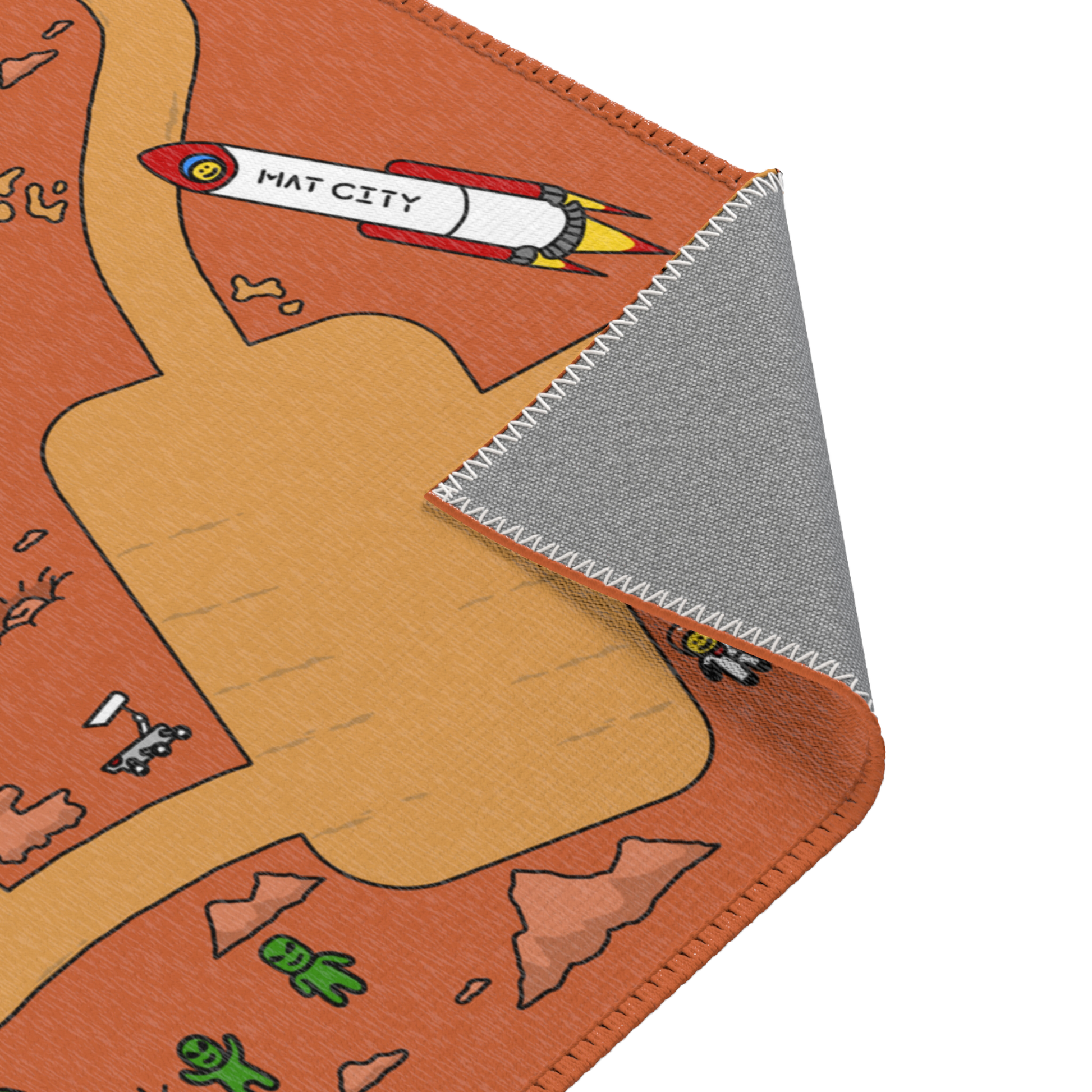 A corner of the Matcity Mars Mat folded over, emphasizing the durable fabric and stitched edges, with a view of the rocket and road in the Mars-themed design.